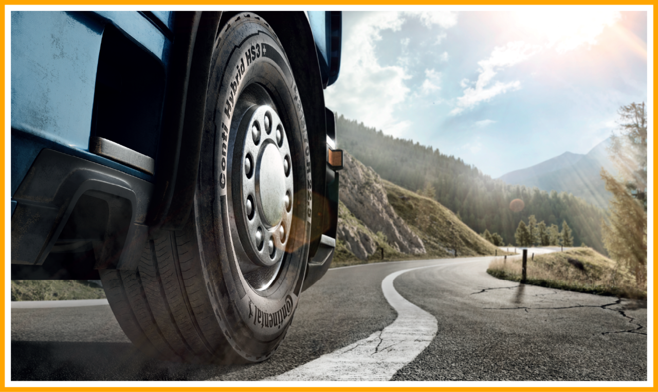 Close-up of a Continental 'Conti Hybrid HS3' truck tire on a winding mountain road.